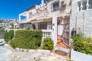 A white building with a gated entrance, a small porch, and a number '2' sign. - Holiday Home in Nerja With Sea Views (Nerja)