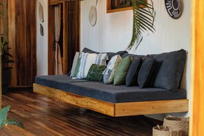 Ein Zimmer mit einer eingebauten Couch, Holzboden und einer kleinen Pflanze.