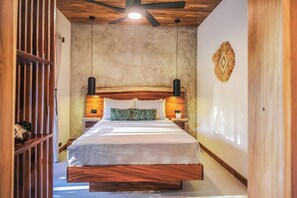 Quarto com cama de madeira, ventoinha no teto e parede texturizada.