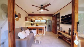 A modern kitchen with a central island, wooden furniture, and a ceiling fan.