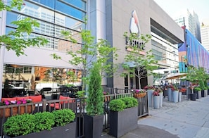 A modern building with a glass facade, outdoor seating, and potted plants. - Luxury Cincinnati Getaway Modern, Stylish & Spacious (Cincinnati)