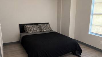 Quarto com cama, janela e ventilador de teto.