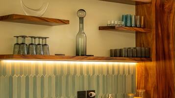 Una cocina con estantes de madera, salpicadero de azulejos y diversos utensilios de cocina.