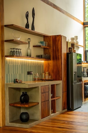 Uma cozinha moderna com armários de madeira, prateleiras embutidas e uma ilha central.
