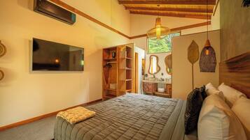 Un dormitorio con cama, armario, espejo y lámpara colgante.