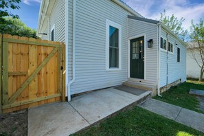 A single-story house with a front door, a small porch, and a wooden fence. - The Shelby House | Historic Charm, Modern Comfort (Shelbyville)