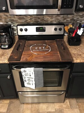 Una cocina con estufa de acero inoxidable, cafetera y bloque de cuchillos.