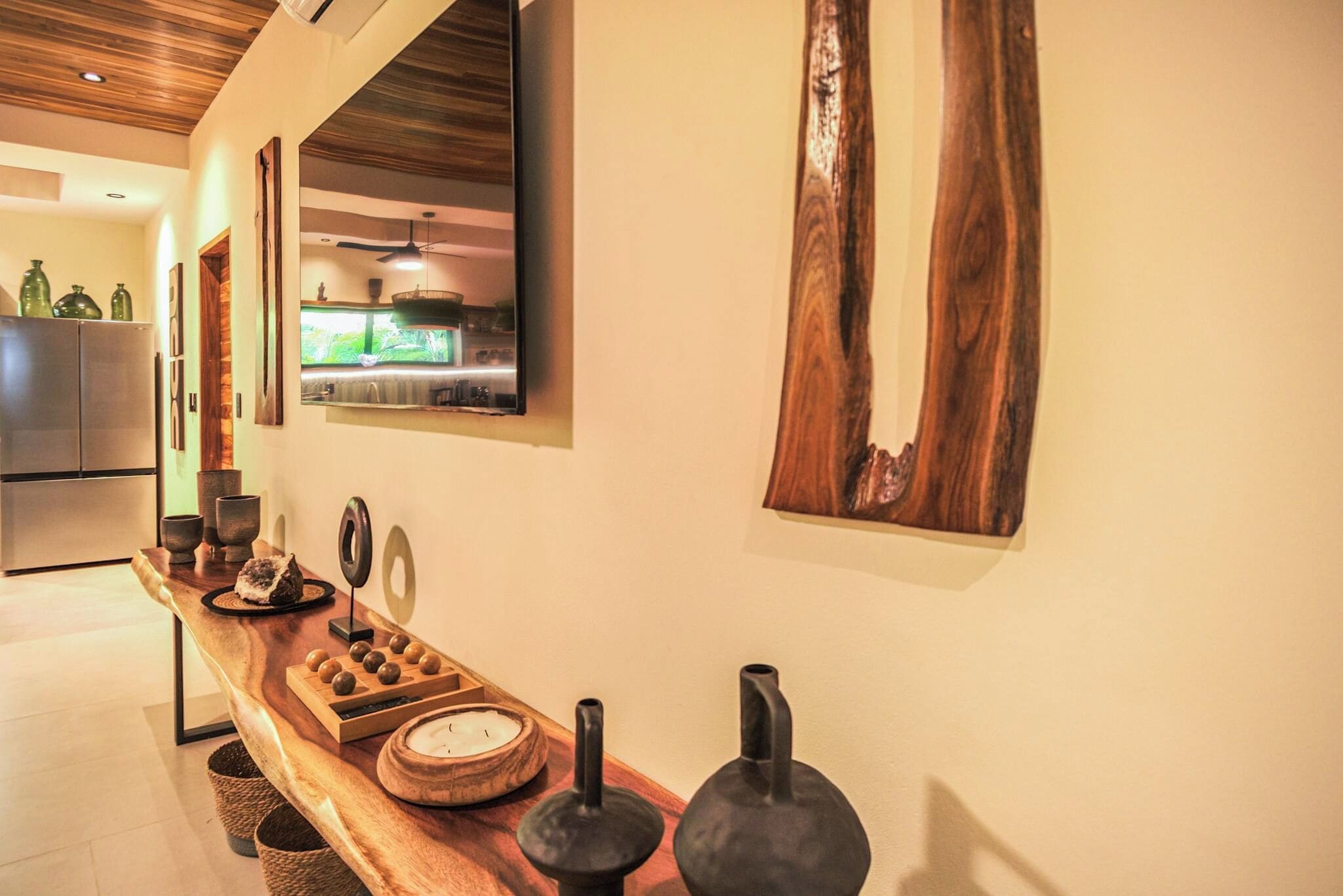 Una cocina con encimera de madera, un refrigerador y una ventana con vista a la vegetación.