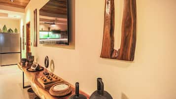 Una cocina con encimera de madera, un refrigerador y una ventana con vista a la vegetación.