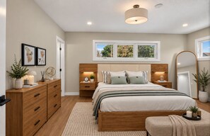 A bedroom with a wooden bed, bedside tables, a mirror, and a window with a view of trees. - Cozy luxurious room with Ensuite washroom in Regina’s best location (Regina)