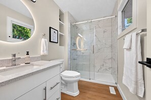 A modern bathroom with a glass-enclosed shower, a white toilet, and a marble-tiled shower area. - Cozy luxurious room with Ensuite washroom in Regina’s best location (Regina)