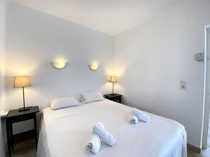 Ein Hotelzimmer mit einem Bett, zwei Nachttischen und Wandlampen.