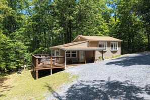 A two-story house with a wooden deck, a covered porch, and a gravel driveway. - Cozy 2-BR Shenandoah Cottage, Pet Friendly (Shenandoah)