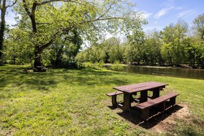 A picnic table in a park with a river in the background. - Cozy 2-BR Shenandoah Cottage, Pet Friendly (Shenandoah)