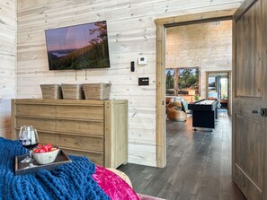 Ein Holzinterieur mit Fernseher, Kommode, Billardtisch und einer gemütlichen Sitzecke.
