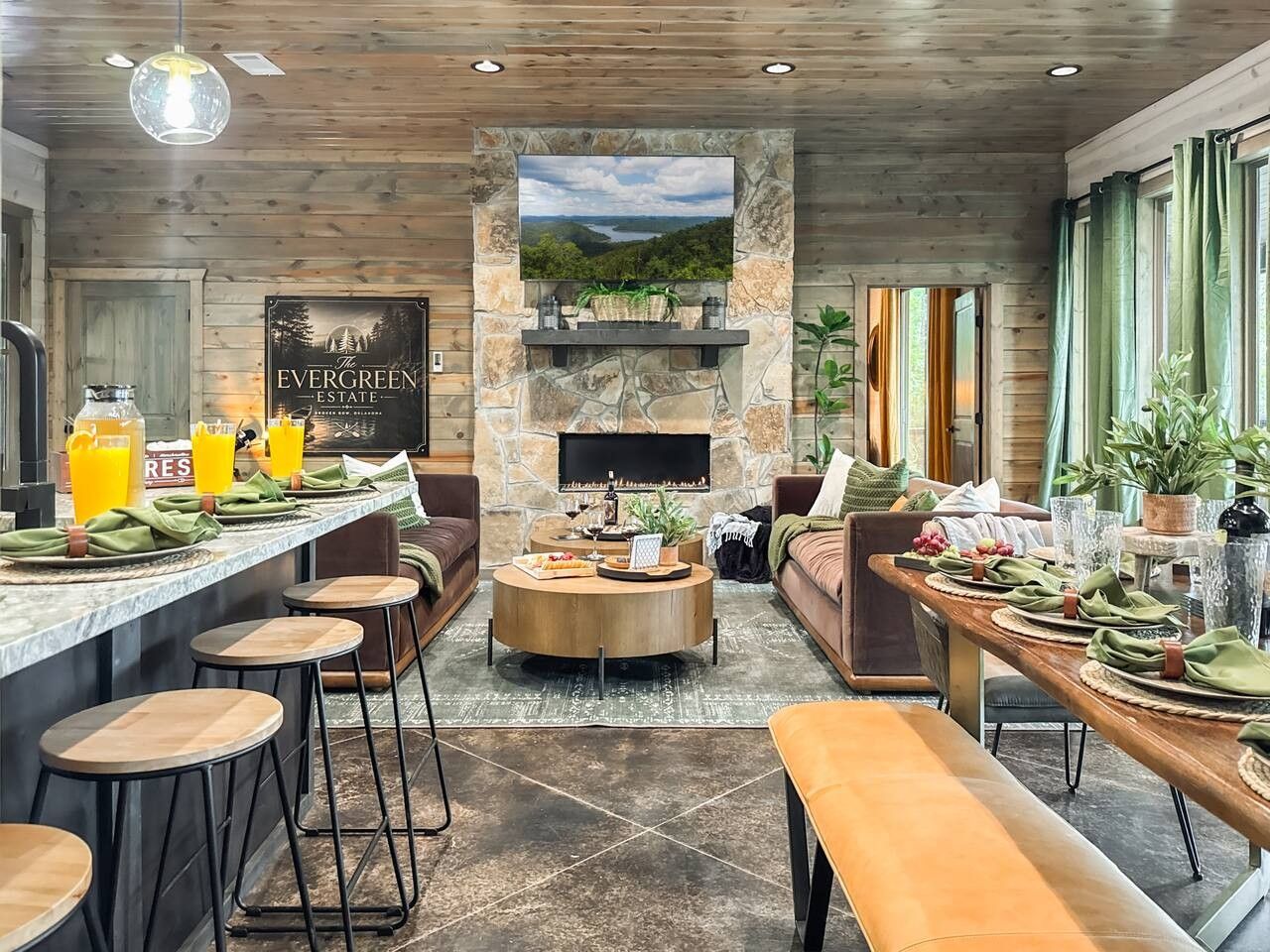Eine moderne Küche mit Steinrückwand, einem großen Flachbildfernseher und einer Bar mit Hockern.