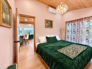 Un dormitorio con una cama grande, una araña de techo y vistas al exterior.