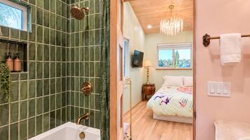 A bathroom with a bathtub, shower, and a toilet.