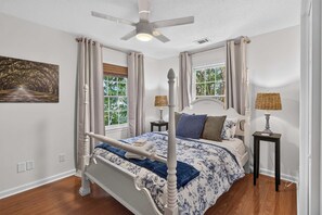 A four-poster bed with a canopy, two bedside tables, a ceiling fan, and a window with curtains. - Savannah Reserve Savannah Row Suite & Hot Tub (Savannah)
