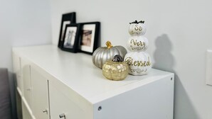 A white cabinet with a stack of decorative snowmen and two pumpkins on top. - Location! Close to Everything! FREE Banff Pass! (Calgary)
