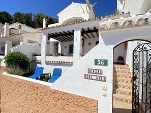 A white building with a number 56 sign, a covered patio area, and a gated entrance. - Apartment in Nerja With Coastal Views & Pool (Nerja)