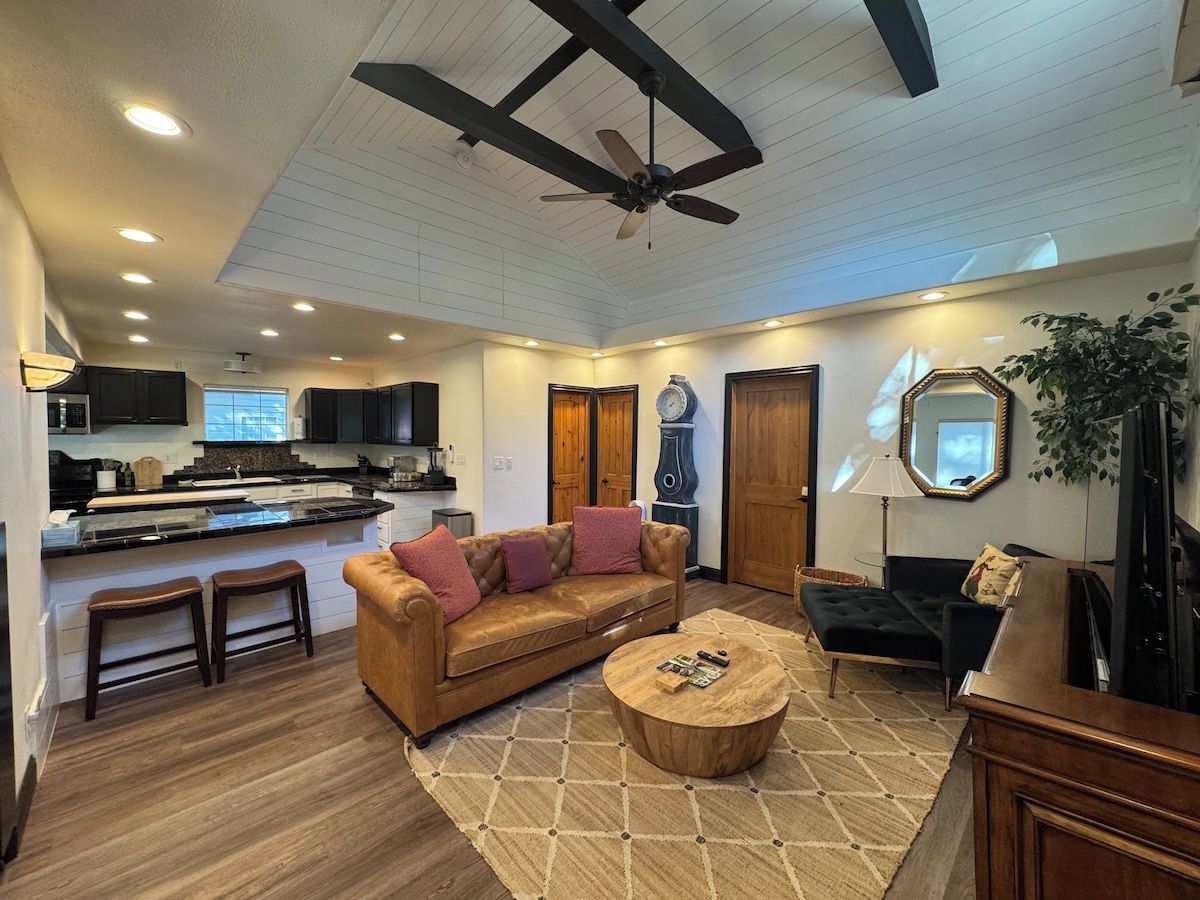 A spacious living area with a sofa, coffee table, and a television.