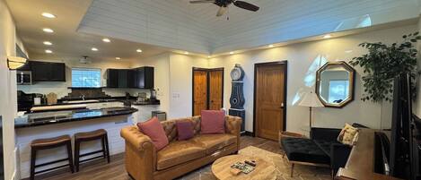 A spacious living area with a sofa, coffee table, and a television.