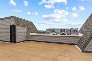 A rooftop terrace with a view of a building complex. - HiTide Condo | Walk to Campus | Prime Gameday Unit (Tuscaloosa)