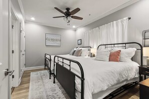 A bedroom with a bed, bedside tables, a ceiling fan, and a window with curtains. - HiTide Condo | Walk to Campus | Prime Gameday Unit (Tuscaloosa)
