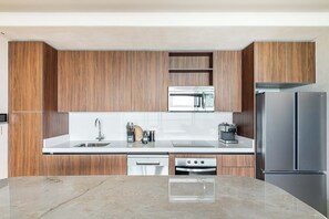 Een moderne keuken met houten kastjes, roestvrijstalen apparatuur en een marmeren aanrecht.