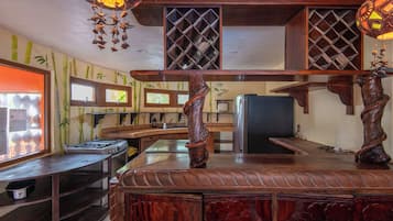 A kitchen with a wooden countertop, a stove, and a refrigerator.