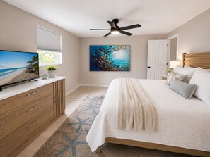 Ein Schlafzimmer mit Bett, Fernseher, Deckenventilator, Gemälde und Fenster mit Jalousien.