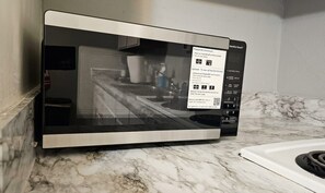 Eine moderne Küche mit integriertem Mikrowellenherd und digitaler Anzeige.