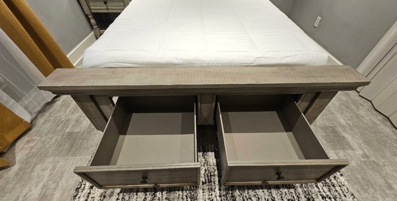 Un dormitorio con cama, dos cajones y piso alfombrado.