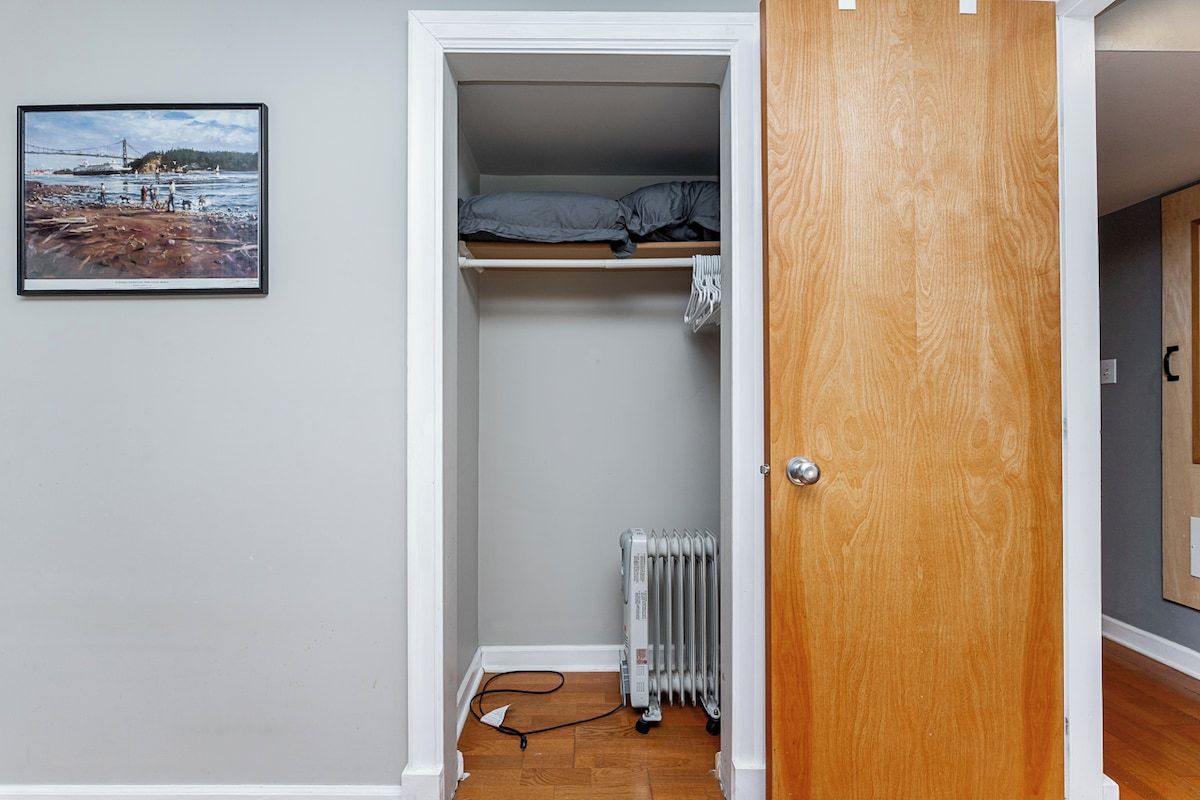 A room with a bed, a radiator, and a framed picture on the wall.