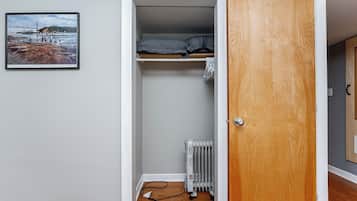 A room with a bed, a radiator, and a framed picture on the wall.
