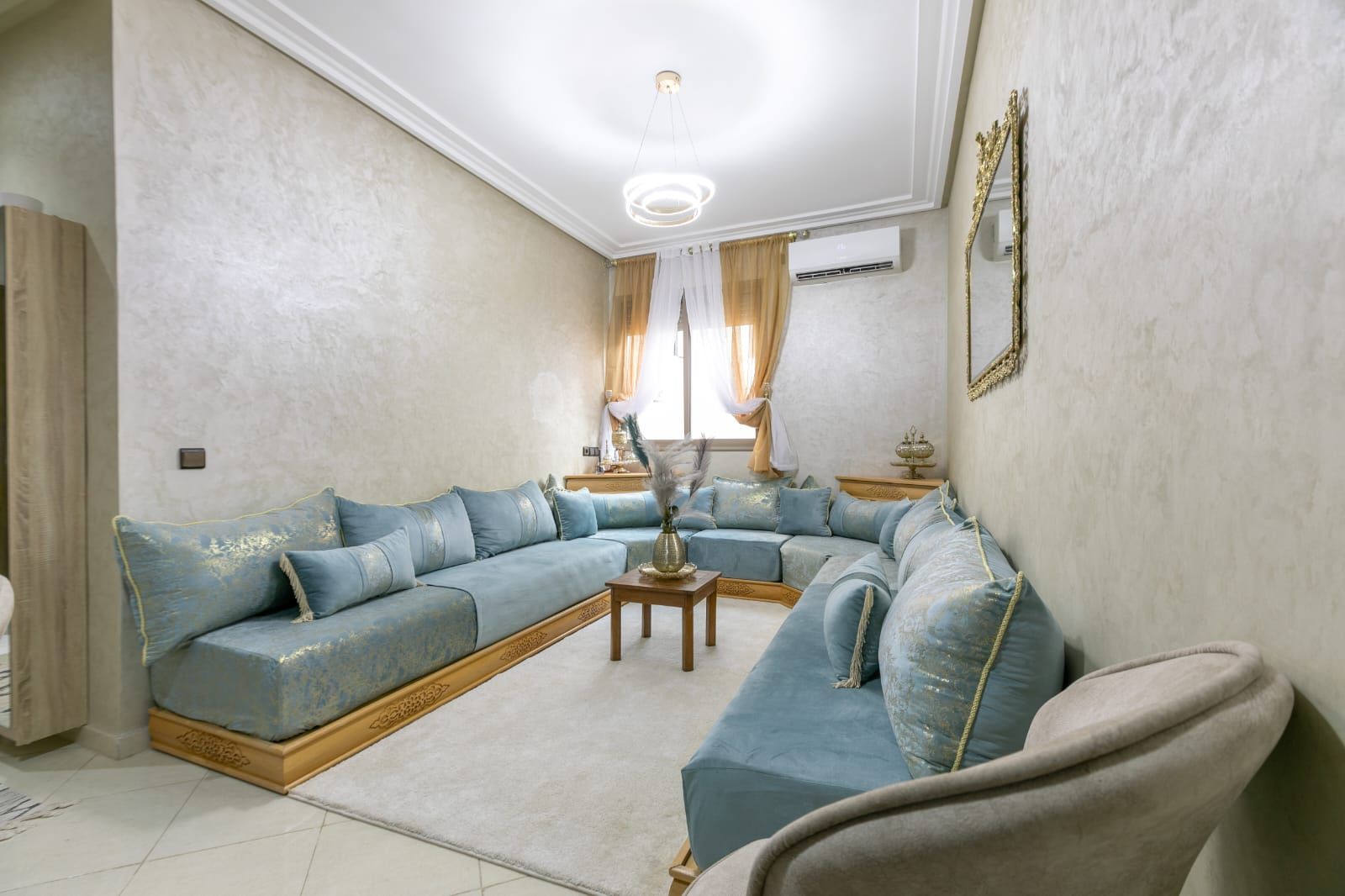 A living room with a sectional sofa, a coffee table, and a decorative vase.