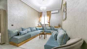 A living room with a sectional sofa, a coffee table, and a decorative vase.