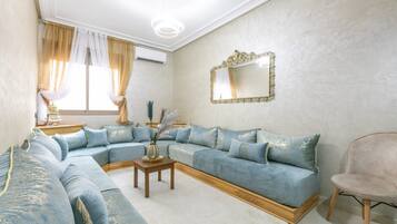 A living room with a sofa set, a side table, a chair, and a decorative mirror.