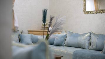 Ein Wohnzimmer mit einem hellblauen Sofa, einem Holztisch und dekorativen Federn.