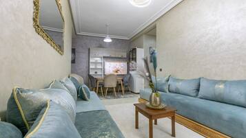 Ein Wohnzimmer mit einer Couch, einem Couchtisch und einem Essbereich mit Stühlen und einem Tisch.