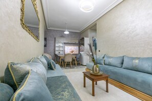 Un salon comprenant un canapé, une table basse et un coin repas avec des chaises et une table.