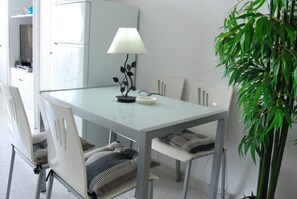 A dining area with a table, chairs, a lamp, and a potted plant. - Studio in Nerja Near Carabeillo Beach (Nerja)