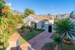 A courtyard with a white building, potted plants, and a paved walkway. - Holiday Home in Nerja With Sea Views (Nerja)
