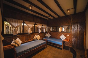 A room with two wooden beds, each with a blue mattress and floral pillows.