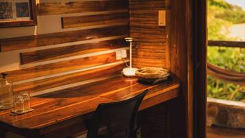 A wooden desk with a chair, a lamp, and a small plant.