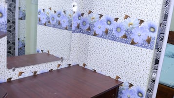 Une salle de bain avec un meuble-lavabo en bois, un miroir et des carreaux muraux à motifs.
