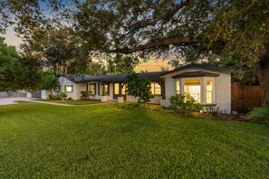 A single-story house with a well-maintained lawn and large trees. - Screened HTD Pool/SPA + Game RM + 15 Min to Beach + Luxury Design + Many Beds (Clearwater)