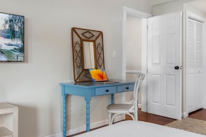 A room with a blue desk, a white chair, a bed, and a white door. - Screened HTD Pool/SPA + Game RM + 15 Min to Beach + Luxury Design + Many Beds (Clearwater)