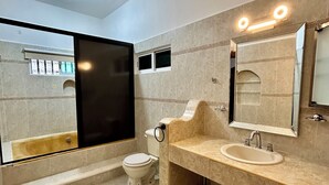 Uma casa de banho moderna com banheira, sanita e lavatório.